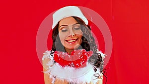 Woman in Santa hat blowing Xmas snowflake.