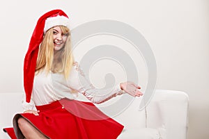 Woman in santa hat with empty hand for copy space