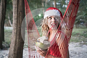 Woman in santa hat on hammock at the beach