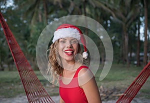 Woman in santa hat on hammock at the beach