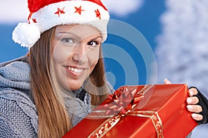 Woman in santa hat holding christmas present