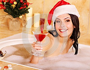 Woman in santa hat relax in bath.