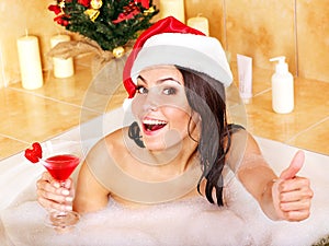 Woman in santa hat relax in bath.