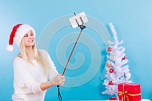 Woman in Santa hat taking Christmas selfie