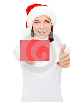 Woman in santa helper hat with blank red card