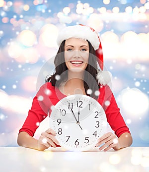 Woman in santa helper hat with clock showing 12