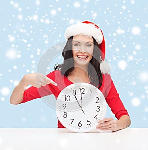 Woman in santa helper hat with clock showing 12