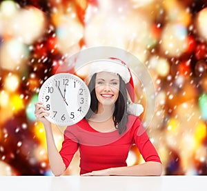 Woman in santa helper hat with clock showing 12