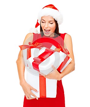 Woman in santa helper hat with many gift boxes