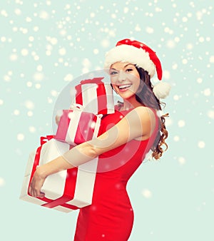 Woman in santa helper hat with many gift boxes