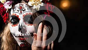 Woman in santa muerte makeup on a black background. Girl wearing traditional mexican holy death costume for halloween photo