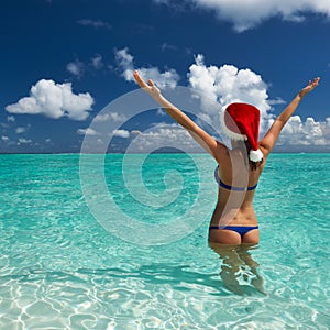 Woman in santa's hat at beach