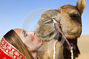 Woman in sari riding a camel.