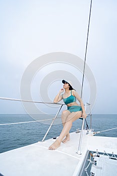 Woman in sarong yachting white sails cruise luxury travel vacation. Young sexy woman on her private yach