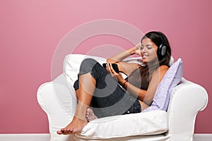 Woman sat in an armchair listening to music