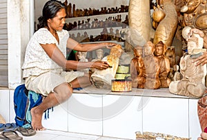 A woman is saturating with stain wooden Buddha