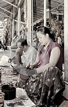 A woman is saturating with stain wooden crafts