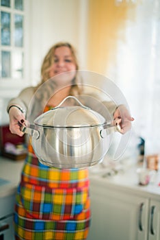 Woman with sauce pan indoor