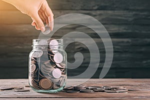 Woman saving coins in jar, dreaming of travel adventures