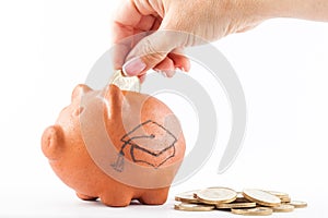 Woman saving money into a traditional clay piggy b