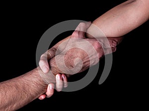 Woman saving, rescuing and helping man by holding or griping the forearm. Female hand and arm pulling up male.