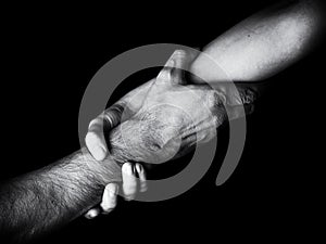 Woman saving, rescuing and helping man by holding or griping the forearm. Female hand and arm pulling up male.