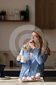 Woman savoring coffee, tranquil kitchen