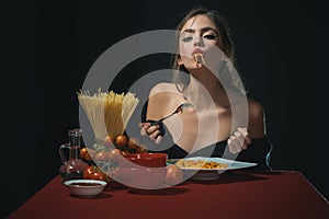 The woman savors the spaghetti with a sensual touch. She enjoys each bite of the pasta in a sensual manner. Food sensual photo