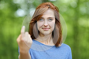 Woman saying come here beckoning in a forest or park