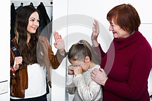 Woman saying goodbye to her mother and upset daughter