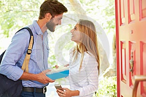 Woman Saying Goodbye To Man Leaving Home With Packed Lunch