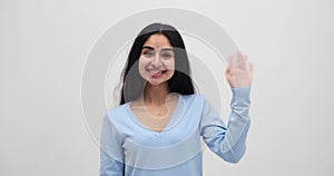 Woman saying hello by waving her hand