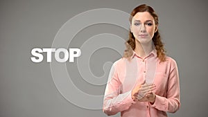 Woman saying stop in sign language, text on background, communication for deaf