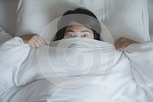Woman with scare and panic while lying down under the blanket in bedroom,Nightmare or bad dream