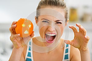 Woman scaring with orange with hallowing face