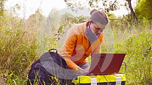 Woman scientist ecologist working on a laptop outdoors photo