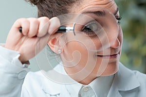 Woman scientist with eye magnified smiles