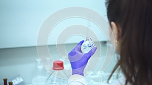 Woman scientist holding lid flask and pipette in chemistry laboratory Spbd. chemical transparent