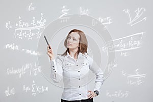 Woman scientist or student with pen working with various high school maths and science formula.
