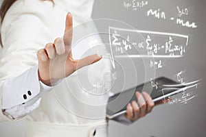 Woman scientist or student working with various high school maths and science formula.