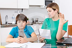 Woman scolding boy at kitchen