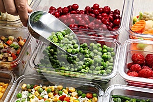 Woman scooping peas from box, closeup