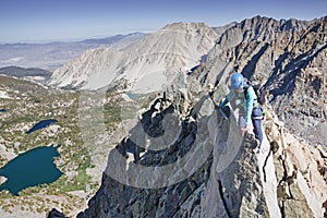 Woman Scrambling Up Mountain Ridge