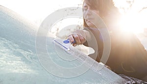 Woman Scraping Ice From Car Windshield