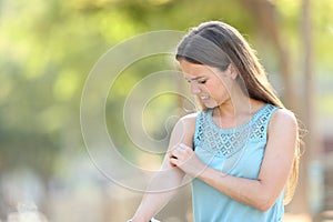 Woman scratching arm because it stings photo