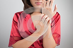 Woman scratching her arm.