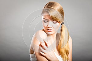 Woman scratching her itchy arm with allergy rash