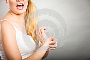 Woman scratching her itchy wrist with allergy rash