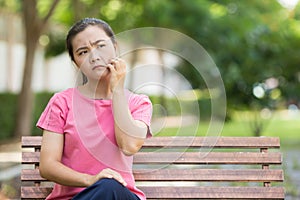 Woman scratching her skin at park garden