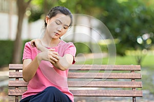 Woman scratching her skin at park garden